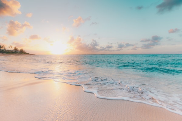 Tropischer Strand mit türkisblauem Wasser bei Sonnenuntergang