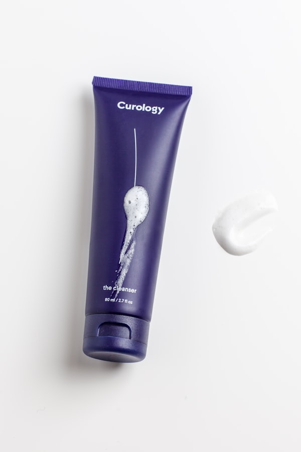 Lila Reinigungs-Tube von Curology, daneben ein Tropfen Cleanser