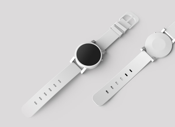 Zwei minimalistische Smartwatches mit weißem Silikonarmband nebeneinander